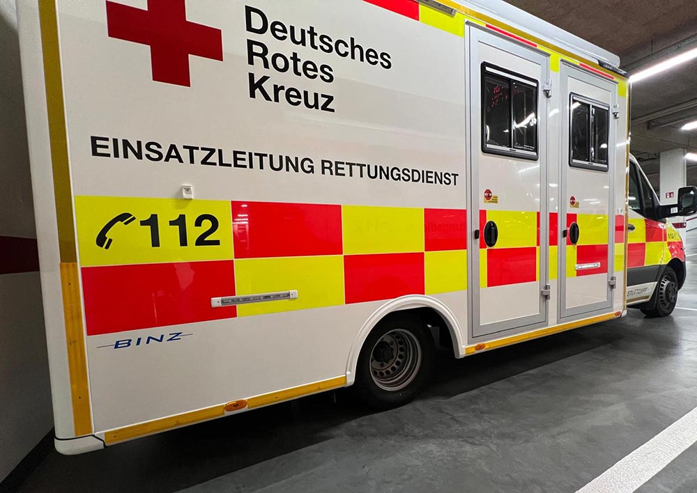 Weisser DRK Rettungswagen mit rotem Kreuz, gelb roten Streifen und 112 Schriftzug in Garage