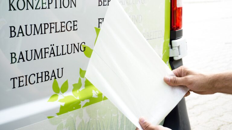 Abziehen von Übertragungspapier bei Fahrzeugbeschriftung